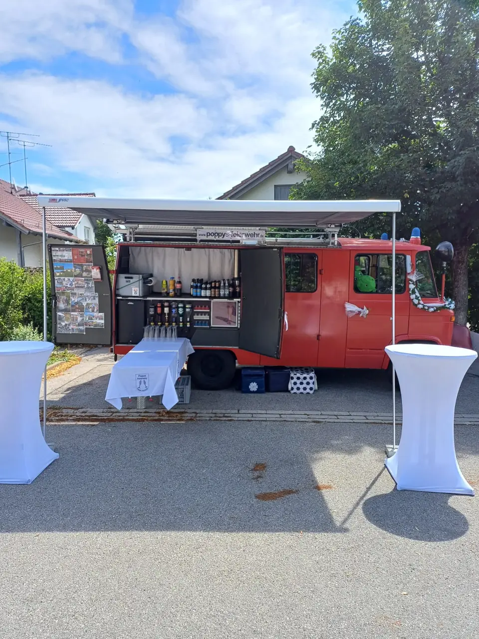 Feuerwehrauto mit geöffneter Bar und Stehtischen