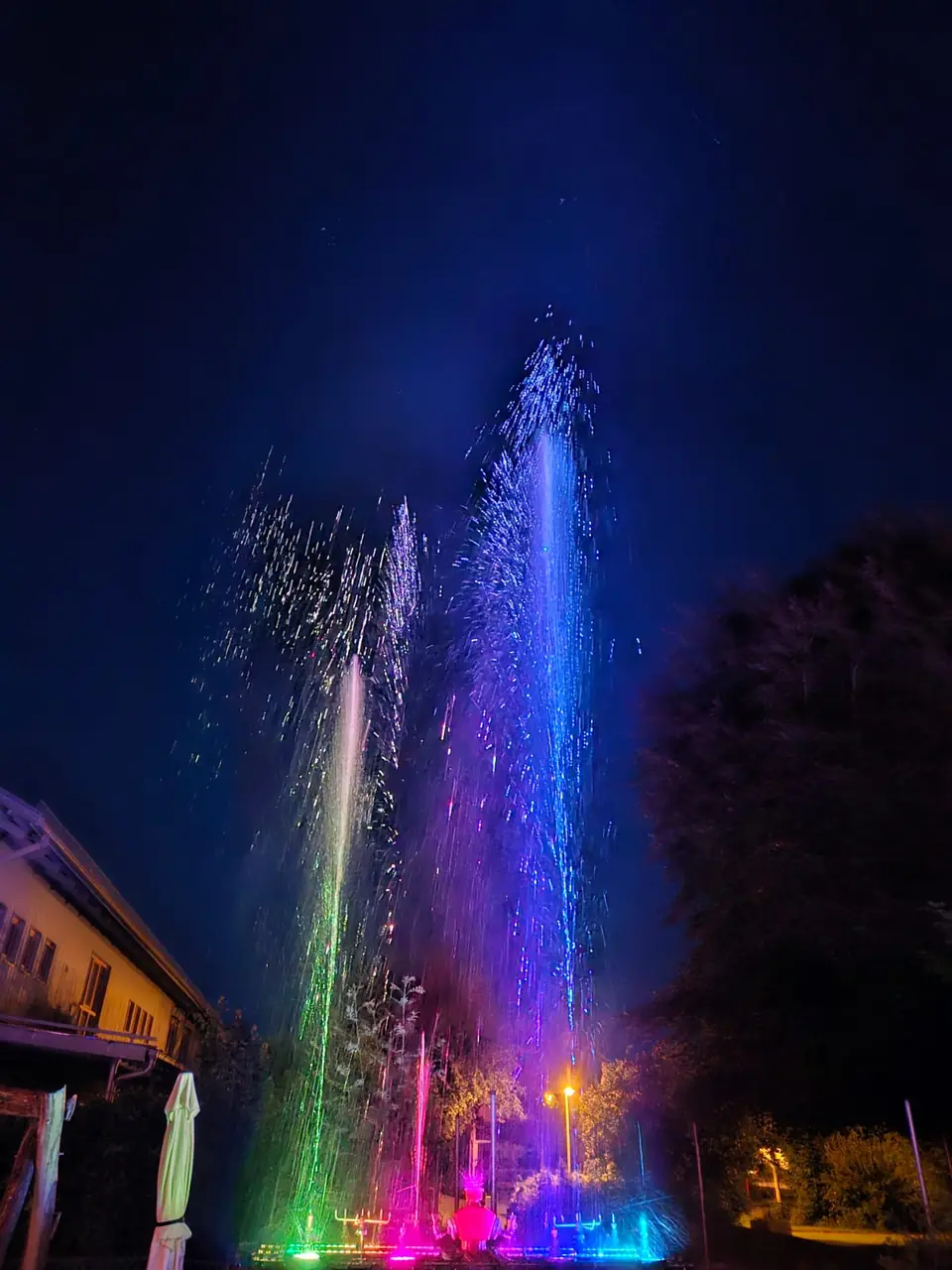 Bunte Wasserfontänen in Blau und Lila